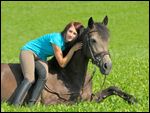 Junge Frau auf liegendem Connemara Pony