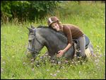Junge Reiterin auf einem liegenden Connemara Pony 