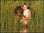 Frau mit Mini-Shetty an einem Teich im Abendlicht 