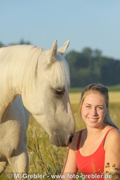 Jugendliche mit palominofarbenem Paso Fino Pferd im Morgenlicht 