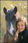 Frau beim Schmusen mit Pony im Herbst 