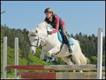 Junge Reiterin mit Sicherheitsweste beim Springen mit Deutschem Reitpony 