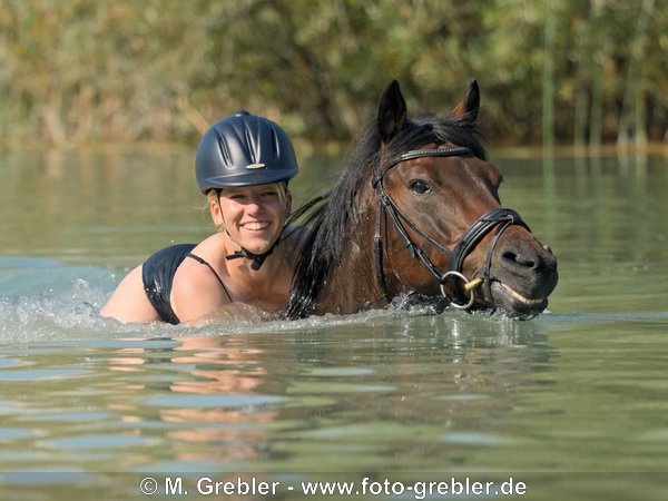 Junge Frau beim Baden mit Reitpony 