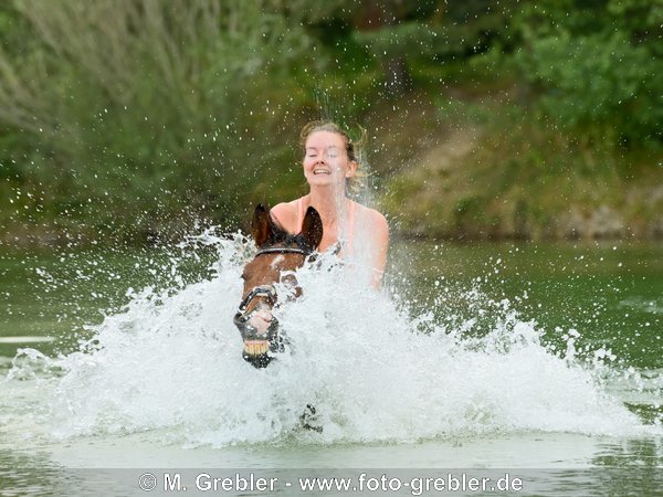 Frau beim Baden mit ihrem Pony 