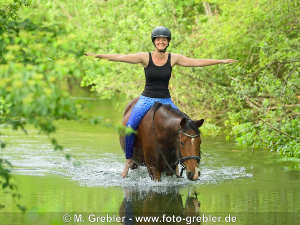 Reiterin ohne Sattel auf Pony im Bach 