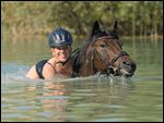 Junge Frau beim Baden mit Reitpony 