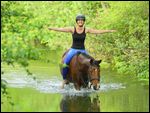 Reiterin ohne Sattel auf Pony im Bach 